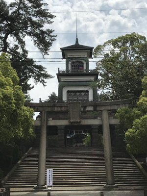 The gate to Oyama Jinja, visible beyond the torii. The red and blue of the stained glass can be seen in the top storey.