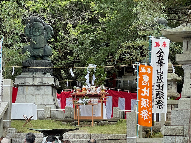 The ritual site for the Ebisu Matsuri. The offerings and himorogi are in the middle, while a statue of Ebisu is visible to the left. The shimënawa that marks off the boundaries of the site is also visible.